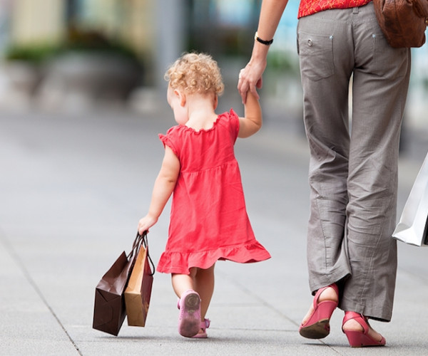 Child and adult walking, holding hands