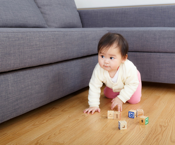 Baby playing with blocks on a wood floor